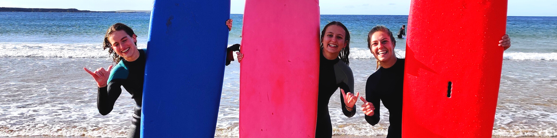 Surf club members standing with their boards